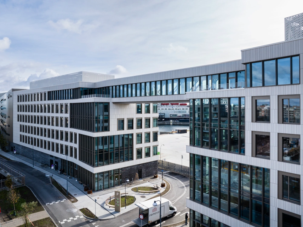 Luftaufnahme des Marmorvej-Gebäudes mit vertikaler, stark profilierter weißer Keramikfassade, die die moderne Bauweise und das städtische Umfeld hervorhebt.