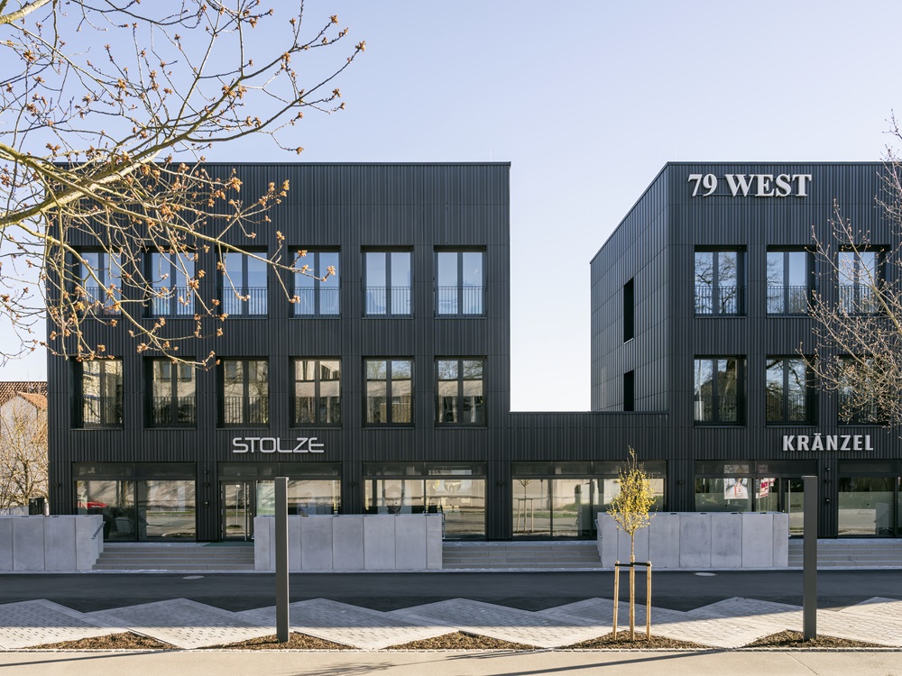 Modernes Geschäftsgebäude mit schwarzer Keramikfassade, Beschriftungen 'STOLZE', '79 WEST' und 'KRÄNZEL' an den Gebäuden.