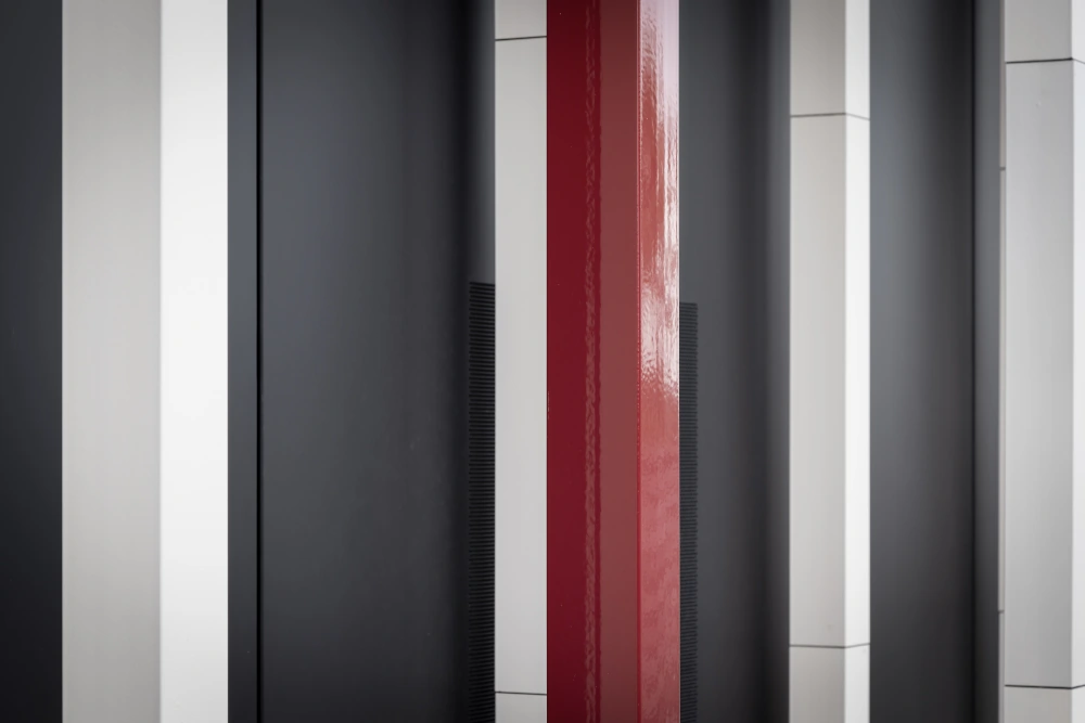 "Nahaufnahme der keramischen Tonality Fassadenplatten an der Universität Augsburg, im Squares-Design in den Farben Weiß und Rot, die moderne Architektur und Nachhaltigkeit betonen."